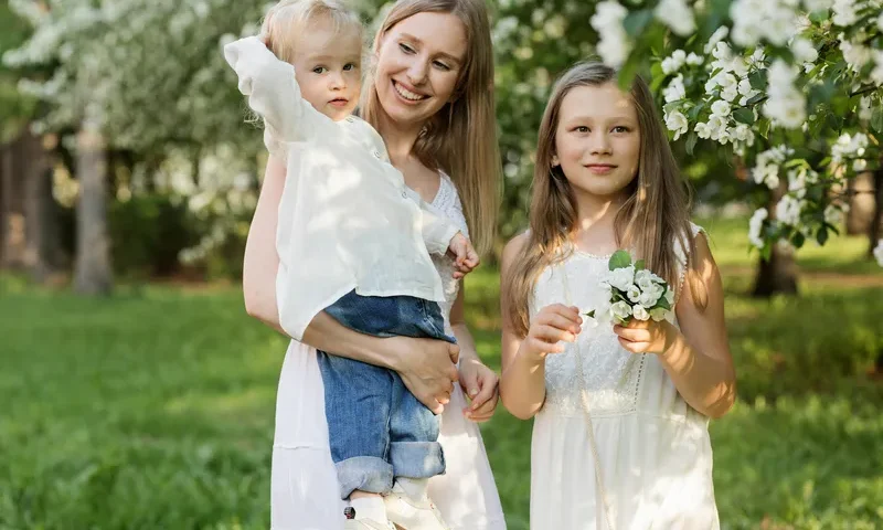 Mama z dwójką dzieci w sadzie.