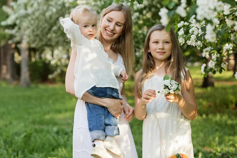 Mama z dwójką dzieci w sadzie.